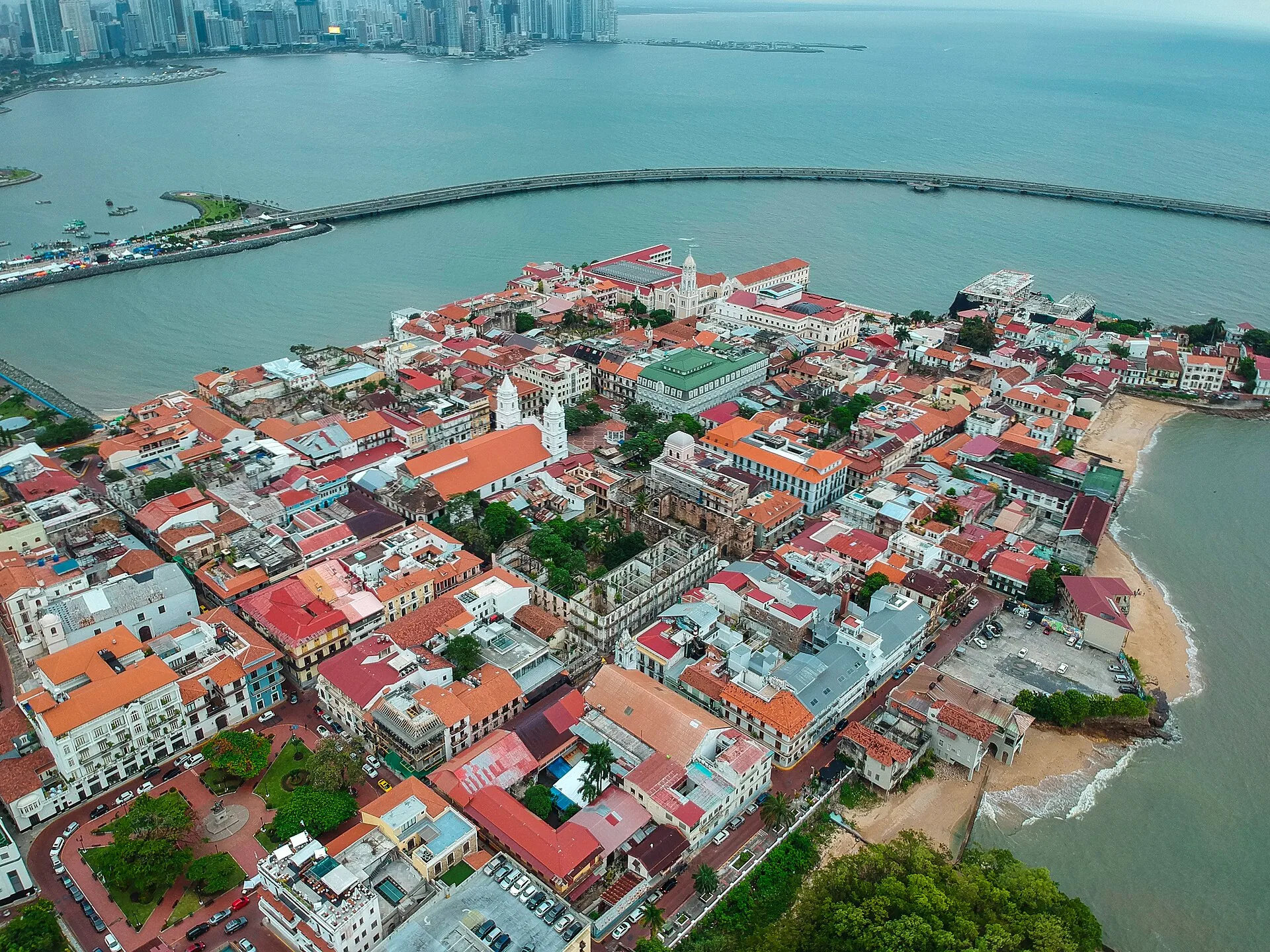 Aerial view of the colorful rooftops of Casco Antiguo, Panama City, with the bay and modern skyline beyond